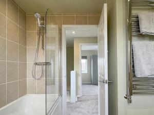 a bathroom with a shower and a bath tub at 'Benson View' - 2 bedroom Lake District home in Kendal