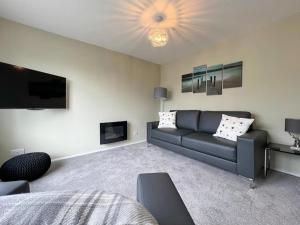 a living room with a couch and a tv at 'Benson View' - 2 bedroom Lake District home in Kendal