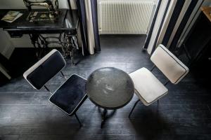 grupa krzeseł i stół w pokoju w obiekcie Chateau des Ayes - Chambres & suites w mieście Saint-Étienne-de-Saint-Geoirs