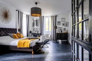 a bedroom with a bed and a chair in it at Chateau des Ayes - Chambres & suites in Saint-Étienne-de-Saint-Geoirs