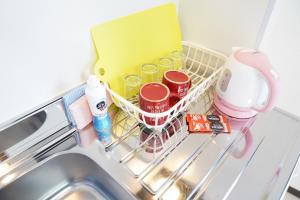einem Geschirrregal mit Lebensmitteln und Reinigungsmitteln in einem Waschbecken in der Unterkunft 難波南34 in Osaka