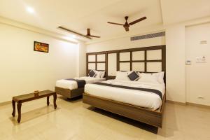 um quarto com 2 camas e uma mesa em Hotel Comfort Park - Opposite Sri Ramachandra Medical College Porur em Chennai