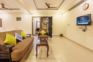 a living room with a couch and a table at Hotel Comfort Park - Opposite Sri Ramachandra Medical College Porur in Chennai