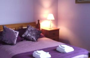Un dormitorio con una cama morada con toallas. en Forest Lake views and fishing, en Troniçais