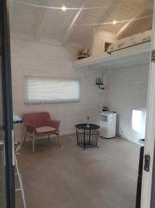 uma sala de estar com uma cadeira vermelha e uma mesa em Maisonnette em Talloires