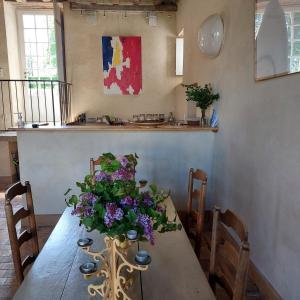 uma mesa de jantar com um vaso de flores em Chateau de Vaux em Gesnes-le-Gandelin