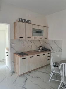 a kitchen with wooden cabinets and a marble counter top at apartment Vujcic 2 in Okrug Donji