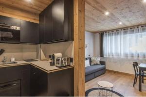 een keuken en een woonkamer met een bank bij Charmant T2 Megève, 10 min à pied du centre in Megève