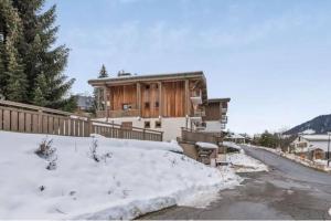 een huis met sneeuw op de grond ervoor bij Charmant T2 Megève, 10 min à pied du centre in Megève