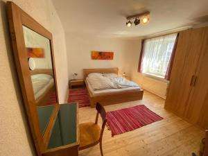Dormitorio pequeño con cama y espejo en Haus Roith, en Ebensee