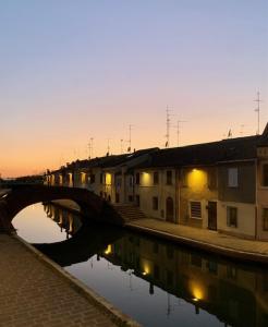 un ponte su un corpo idrico con edifici di AGATOPISTO Animo Salmastro a Comacchio