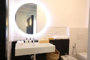bagno con lavandino bianco e specchio di AGATOPISTO Animo Salmastro a Comacchio