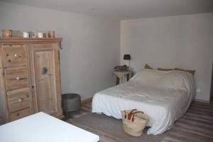 a bedroom with a bed and a dresser and a basket at La maison de Barbara in Aubel +11 photos