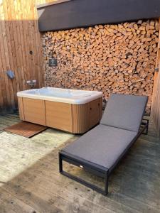 une baignoire assise à côté d'une pile de bois dans l'établissement 4 DOMY, à Dolní Morava