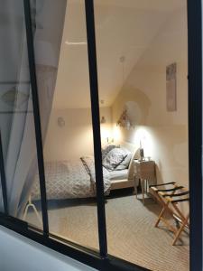 a bedroom with a bed and a window at Au domaine de Gigie in Chervettes