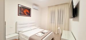Dormitorio blanco con cama blanca y mesa en Farah’s house, en Padua