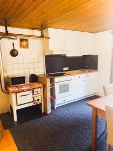 a kitchen with white cabinets and a stove top oven at Ferienwohnung Steinberger in Fügenberg