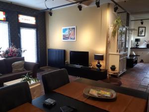 - un salon avec un canapé et une télévision dans l'établissement familiehuis Amber, à Haaksbergen