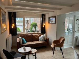 a living room with a couch and a table at Pollux bij Vuurtoren en strand in Noordwijk aan Zee