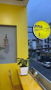 a table with a potted plant on a yellow wall at Dalat Friendly Fun in Da Lat
