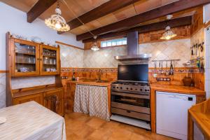 西內烏的住宿－Finca Pep，厨房配有木制橱柜和炉灶烤箱。