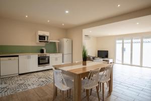 - une cuisine avec une table en bois et des appareils électroménagers blancs dans l'établissement Villa de 200 m2 avec piscine proche du centre-ville, à Avignon