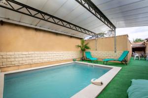 - une piscine avec 2 chaises et une table dans l'établissement Villa de 200 m2 avec piscine proche du centre-ville, à Avignon