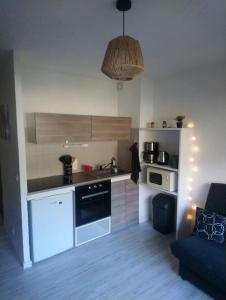 una cucina con piano cottura e un divano in camera di Appartement aux pieds des pistes / piscine a Saint-Gervais-les-Bains