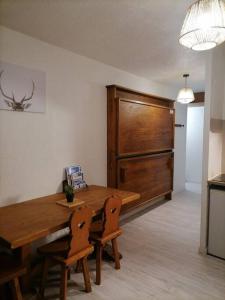 a dining room with a wooden table and two chairs at Appartement aux pieds des pistes / piscine in Saint-Gervais-les-Bains