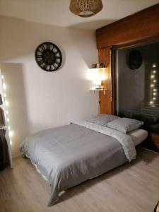 una camera con un grande letto e un orologio a muro di Appartement aux pieds des pistes / piscine a Saint-Gervais-les-Bains