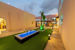 un patio con piscina en el centro de un edificio en قصر الممشى للشقق الفندقية en Jazan
