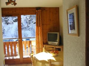 Televízia a/alebo spoločenská miestnosť v ubytovaní Appartement de standing au pied des pistes