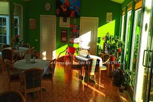 a dining room with a table and chairs and green walls at Villa Ostmala in Ventspils