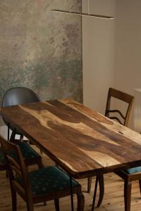 una mesa de comedor de madera con sillas alrededor en Designwohnung auf Gutshof mit Sauna zw. L/DD, en Mügeln