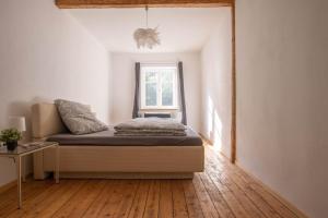 1 dormitorio con cama y ventana en Designwohnung auf Gutshof mit Sauna zw. L/DD, en Mügeln