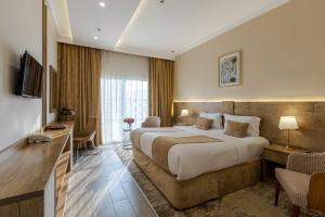 une chambre d'hôtel avec un grand lit et un salon dans l'établissement Hotel 21, à La Mecque