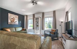 ein Wohnzimmer mit einem Sofa und einem TV in der Unterkunft Cozy Home In Den Ham With Kitchen in Den Ham