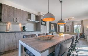eine Küche und ein Esszimmer mit einem Holztisch und Stühlen in der Unterkunft Cozy Home In Den Ham With Kitchen in Den Ham