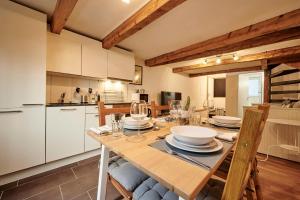 uma cozinha com uma mesa de madeira com pratos e copos de vinho em Lakeside Tiny House Brienz em Brienz
