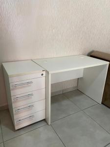a white desk with a white drawer and a deskictericter at Ap flat central- ar, garagem e ótima localização in Foz do Iguaçu