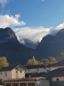 a group of buildings and mountains with clouds in the background at superbe appartement en résidence prive avec un parking prive in Scionzier