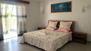 a bedroom with a bed with pink pillows and a window at Nosy Bay View in Nosy Be