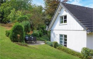 una casa blanca con sillas negras en un patio en Beautiful Home In Attendorn With Wifi And 2 Bedrooms, en Attendorn