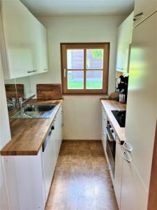 a kitchen with white cabinets and a window at Haus Rheintalblick in Übersaxen