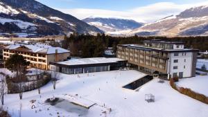einen Luftblick auf ein Resort mit schneebedeckten Bergen in der Unterkunft Garden Park Hotel in Prad am Stilfserjoch