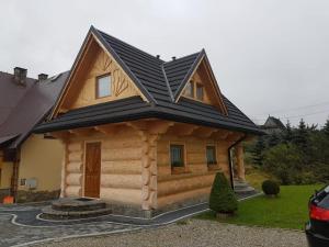 uma cabana de madeira com um telhado preto em U Garczków em Witów