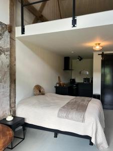 een slaapkamer met een wit bed en een keuken bij De Citadel - De Boomgaard in Markelo