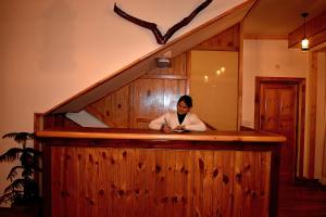 a woman sitting at a bar in a room at THE LANDSBY COTTAGES in Nagar