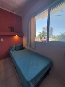 Dormitorio pequeño con cama y ventana en Departamento practico, con buena iluminación y ubicación. en Paraná