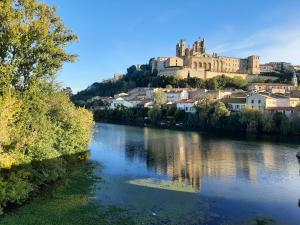 a view of a river with a castle in the background at Situation parfaite, calme et spacieux, Wifi fibre, Netflix & Prime in Béziers